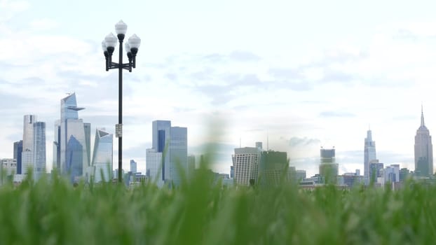 New York City, United States - 11 Sept 2023: Waterfront skyline, Manhattan Midtown Hudson Yards, riverfront skyscrapers. Waterside cityscape from Pier A Park, Hoboken, New Jersey. People on grass lawn