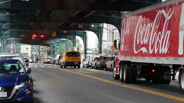 New York City, United States - 13 Sept 2023: Coca-cola truck, elevated subway above street. Metropolitan bridge over road, Queens. Long Island metro line. Coca cola delivery, Coke lorry, railway track