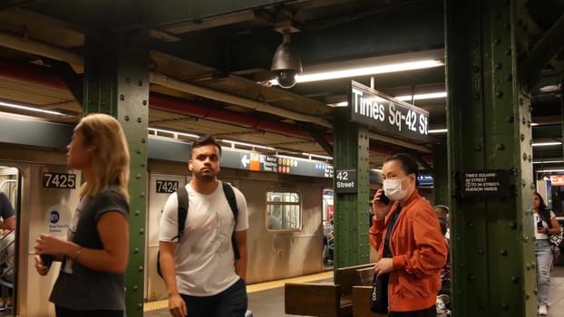 New York City, United States - 1 Sept 2023: Subway station, underground metropolitan train platform sign. Metro railway passenger public transport. Times Square text signboard. People. Manhattan.