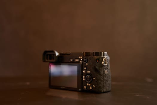Sony A6000 digital mirrorless camera stands on a black marble table. Back view. High quality photo