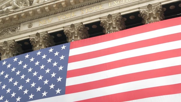 New York City, United States - 9 Sept 2023: Lower Manhattan Downtown Financial District urban architecture. Huge big American flag. Wall street Stock Exchange building, USA Stock Market trading.