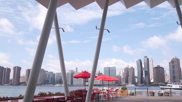 New York City, United States - 30 Aug 2023: Waterfront skyline, Manhattan Midtown buildings, riverfront skyscrapers by East river. Waterside cityscape, Hunters Point pier columns, Long Island, Queens.