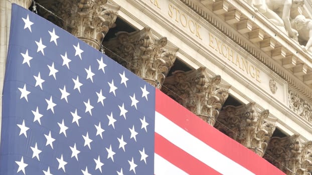 New York City, United States - 9 Sept 2023: Lower Manhattan Downtown Financial District urban architecture. Huge big American flag. Wall street Stock Exchange building, USA Stock Market trading.