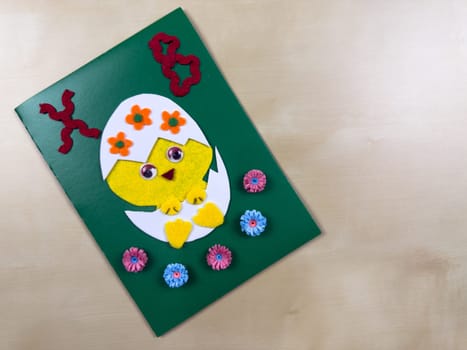 This delightful handmade Easter card features a cute chick emerging from an egg, adorned with colorful flowers. Perfect for sending warm wishes and spreading joy during the holiday season