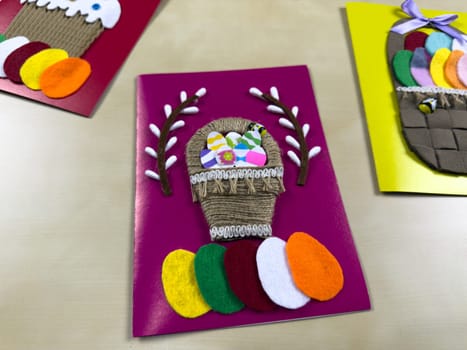 Vibrant handmade Easter card features basket filled with assorted felt eggs and cheerful decoration. Perfect for sharing warm wishes and celebrating joyful spirit of Easter with family and friends