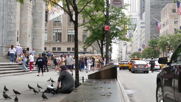 New York City, United States - 11 Sept 2023: Manhattan Midtown street, Fifth 5 avenue, 5th ave, American urban road car traffic, Yellow taxi, USA. Patricks Cathedral. People, pigeons, homeless beggar.