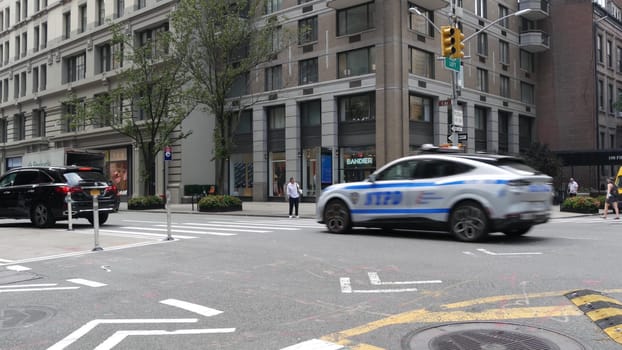 New York City, United States - 8 Sept 2023: Police patrol car, USA NYPD, 911 vehicle on Manhattan Midtown street. American cop auto siren light on Fifth 5 avenue. Urban traffic, road transport scene.