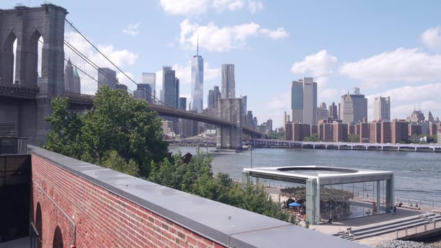 New York City, United States - 30 Aug 2023: Manhattan downtown skyline, waterfront cityscape from Time Out Market. Riverfront Carousel in Dumbo near Brooklyn Bridge. World Trade Center skyscraper.