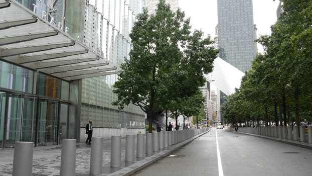 New York City, United States - 10 Sept 2023: Manhattan Downtown Financial District. People near World Trade Center Oculus. Memorial pools and 911 Museum area, Fulton street architecture in USA. Trees.