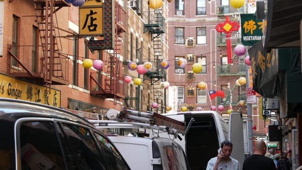 New York City, United States - 14 Sept 2023: Manhattan Chinatown Pell street. Chinese culture, ethnic district architecture, USA. Red brick buildings, round paper lanterns and hieroglyph signs. People
