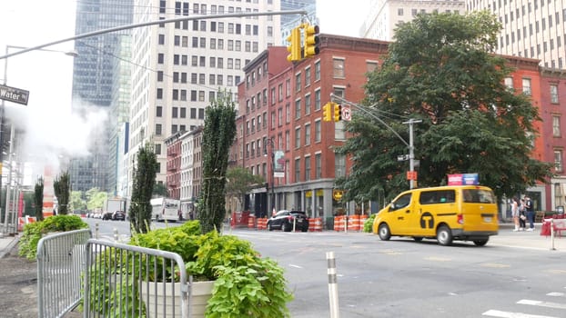 New York City, United States - 9 Sept 2023: Manhattan Downtown Financial District Water street crossroad intersection. USA. Urban road car traffic. Yellow taxi, people. Hot smoke stack, steam pipe.