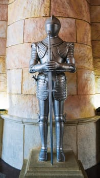 statue of a medieval knight in metal armor armed with a sword