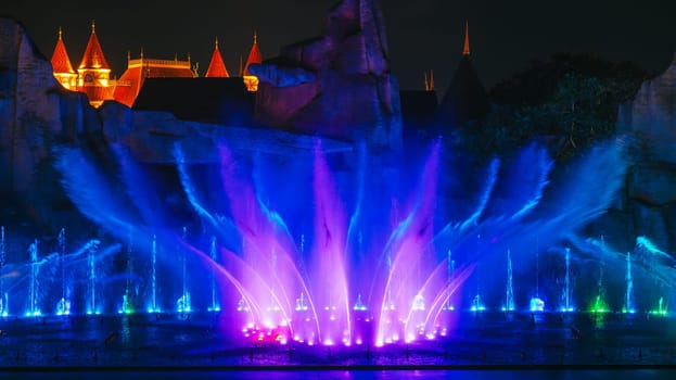 beautiful bright blue illuminated dancing and singing fountains at night. Musical water performance show