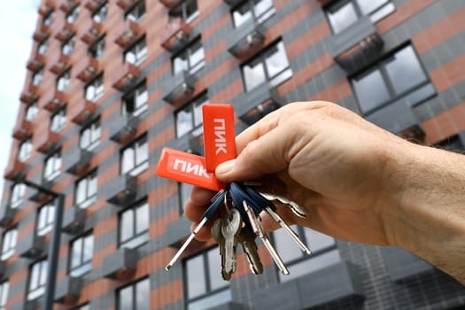 Vidnoe, Russia - Aug 10, 2022. Keys to the new building of the construction company PIK in man's hand