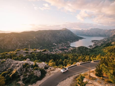Car drives along a highway in the mountains above the Bay of Kotor. Montenegro. Drone. High quality photo
