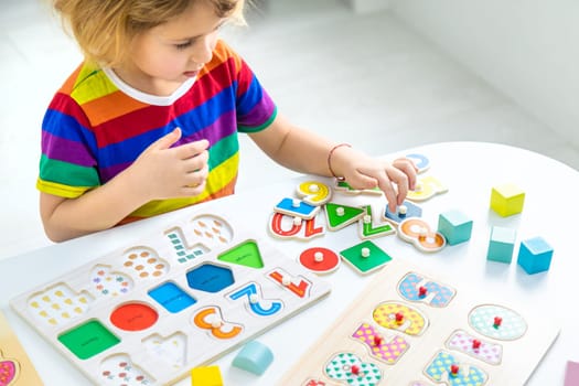Child learns numbers and letters. Selective focus. Kid.