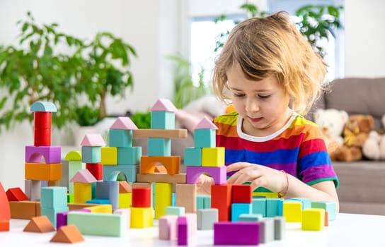A child builds from blocks. Selective focus. kid.