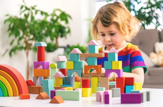 A child builds from blocks. Selective focus. kid.