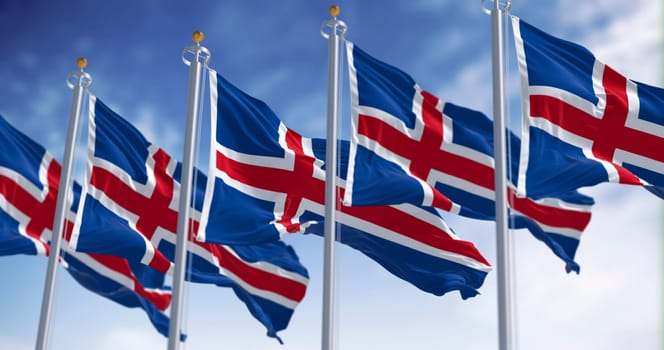 Multiple Icelandic flags waving dynamically in the wind, symbolizing national pride, unity and freedom against a bright sky.