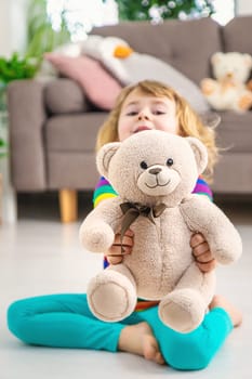 Child loves teddy bear at home. Selective focus. kid.