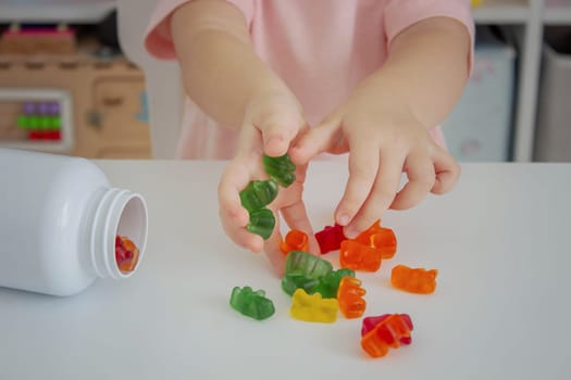 Little girl eating jelly candies or vitamins. child.