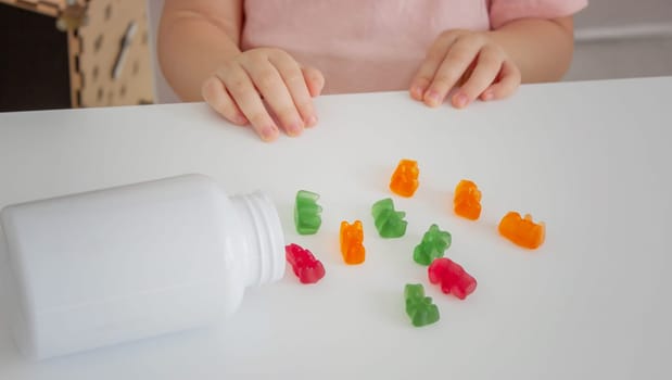 Little girl eating jelly candies or vitamins. child.