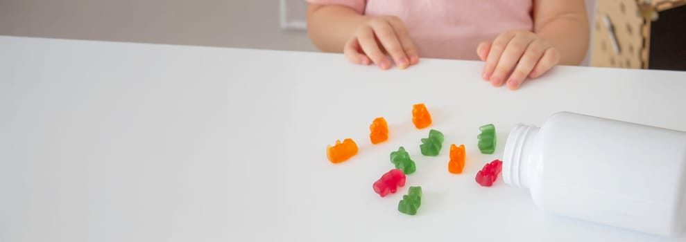 Little girl eating jelly candies or vitamins. child.