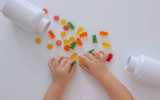 close-up of a little girl's hand taking jelly beans or vitamins