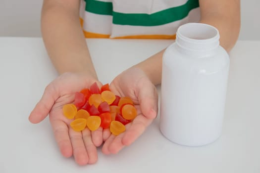 The boy eats jelly beans or takes vitamins.