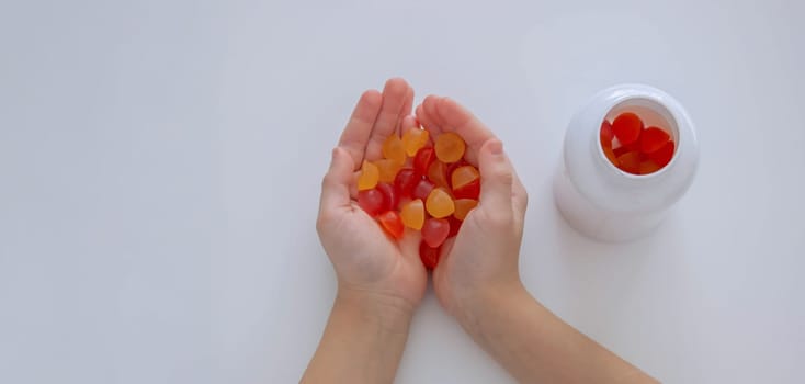 The boy eats jelly beans or takes vitamins.
