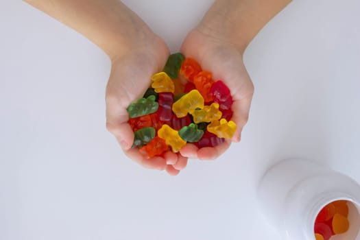 The boy eats jelly beans or takes vitamins.