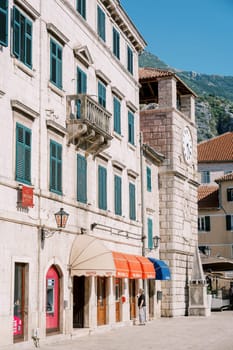 Old stone building with colorful coverings near the ancient clock tower. Kotor, Montenegro. High quality photo