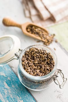 Milk thistle seeds in jar on a kitchen table.