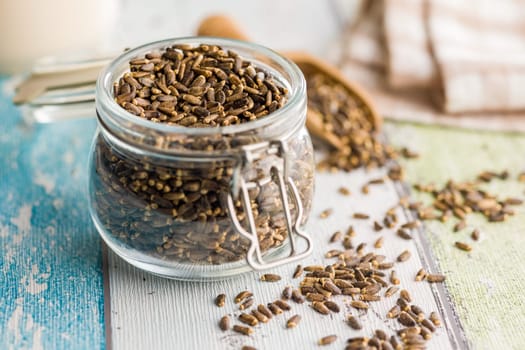 Milk thistle seeds in jar on a kitchen table.
