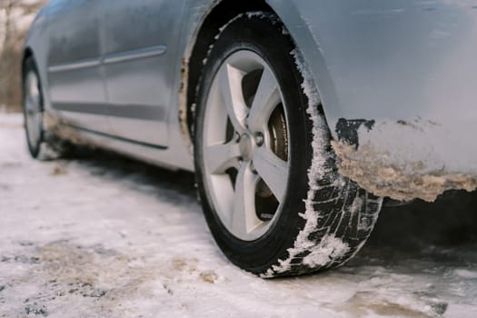 Back of the car with dirty snow near the wheel and under the body. High quality photo