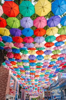 Hanging multicolored bright colorful umbrellas decorating festive street on Magic City Park in Tashkent. Tashkent, Uzbekistan - June 15, 2024