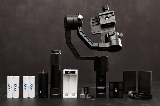 FeiyuTech G6 Steadicam with accessories stands on a marble table on a black background. High quality photo