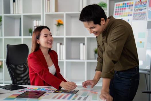 Two designers engage in a dynamic discussion while reviewing color options, showcasing the synergy of teamwork in a creative environment.