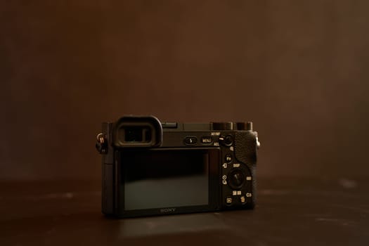 Sony A6000 mirrorless camera stands on a black table. High quality photo