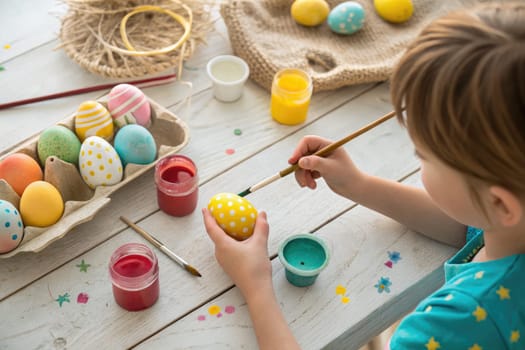 A playful child decorates Easter eggs on a sunny afternoon, using vibrant paints and brushes.