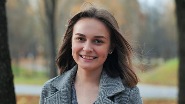 Portrait of a smiling young girl in an autumn park
