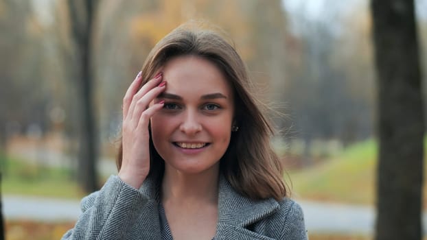 Portrait of a smiling young girl in an autumn park