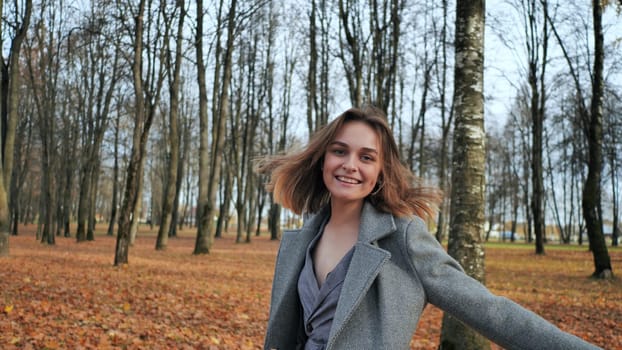A beautiful and happy girl is walking in the autumn park