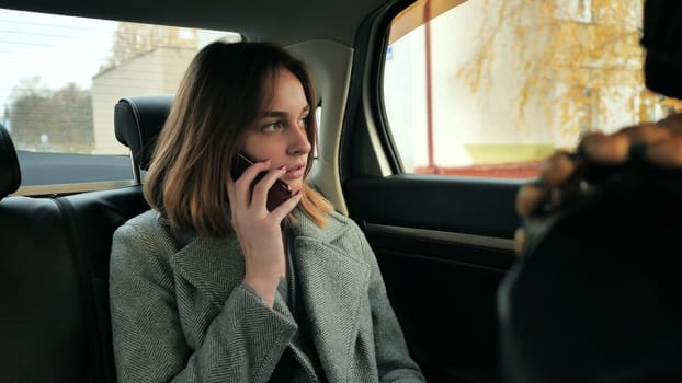 The girl in the car is talking on the phone