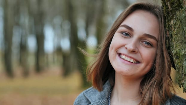 Beautiful happy smiling young girl in autumn park