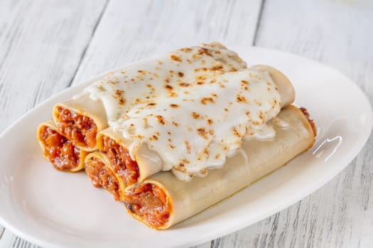 Delicate cannelloni pasta, generously filled with rich bolognese sauce, baked under a blanket of melted mozzarella