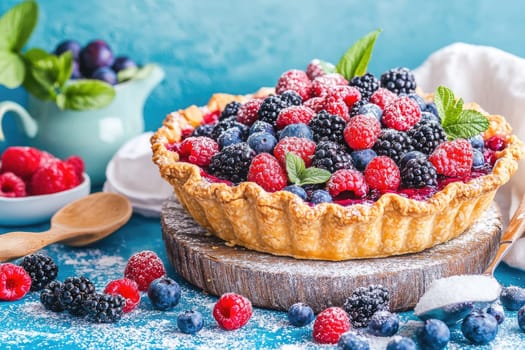 A delicious rustic open-faced pie showcases an array of seasonal berries, including raspberries, blueberries, and blackberries, bursting with flavor. The pie's edges are perfectly crisp and have a slight caramelized sheen, inviting anyone to savor a slice. A light dusting of sugar adds a sweet touch, while fresh mint leaves garnish the vibrant filling. This delightful dessert is the perfect centerpiece for any gathering, evoking the warmth of homemade treats shared with loved ones.