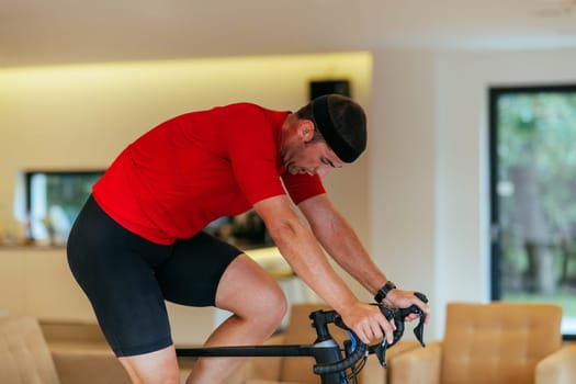 A triathlete riding a triathlon bike on a machine simulation in a modern living room.