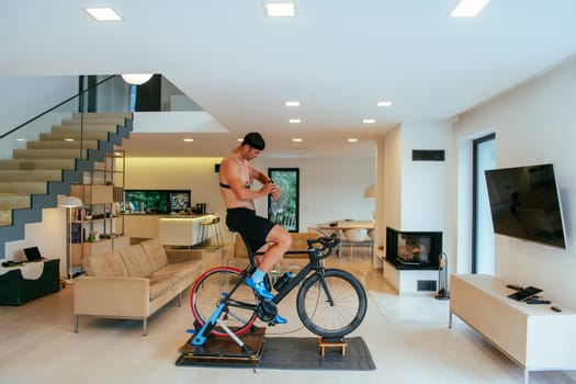 A triathlete riding a triathlon bike on a machine simulation in a modern living room.