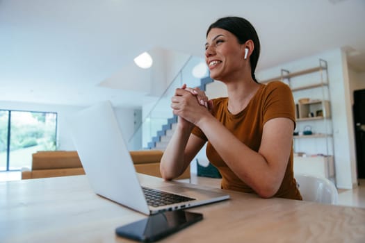 Woman sitting in living room using laptop looking at cam talk by video call with business friend relatives, head shot. Job interview answering questions